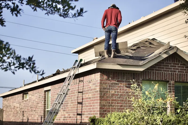 Professional roofer working on a residential roof in Kenmore